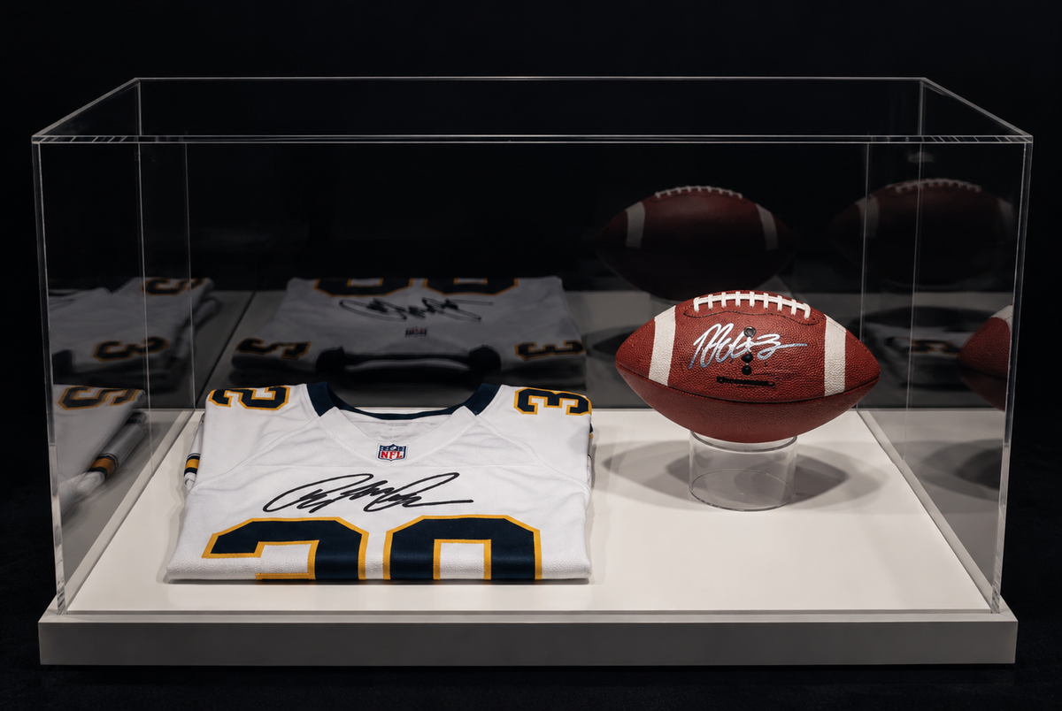 American football en gesigneerd sportshirt onder een transparante kap.